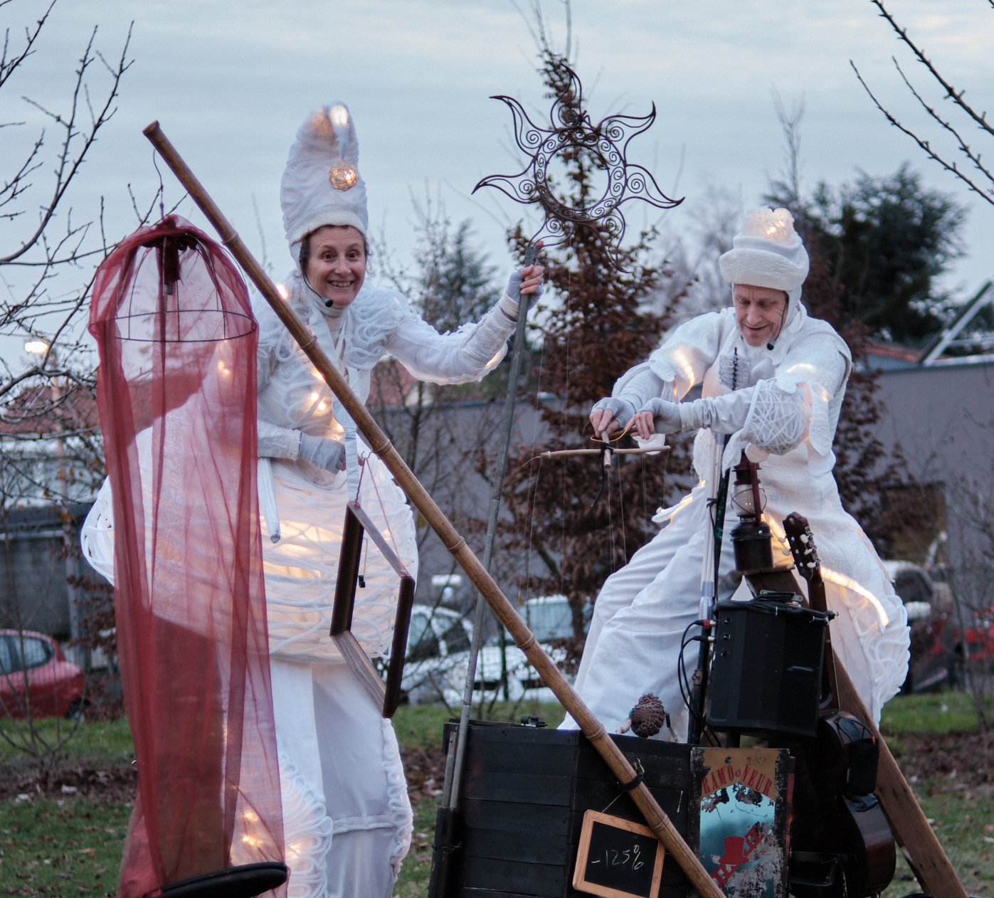 Compagnie de théâtre professionnelle Deux échassiers lumineux blancs, appelés Anges Lumineux, lors d’un spectacle de rue poétique